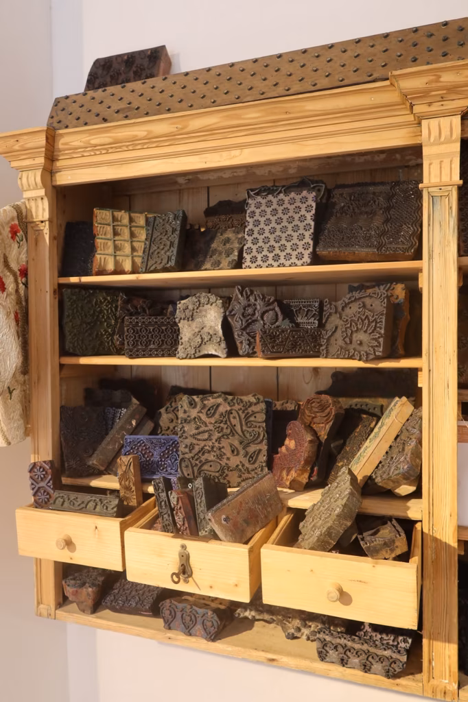 Regal mit historischen Holzmodeln in offenen Schubladen